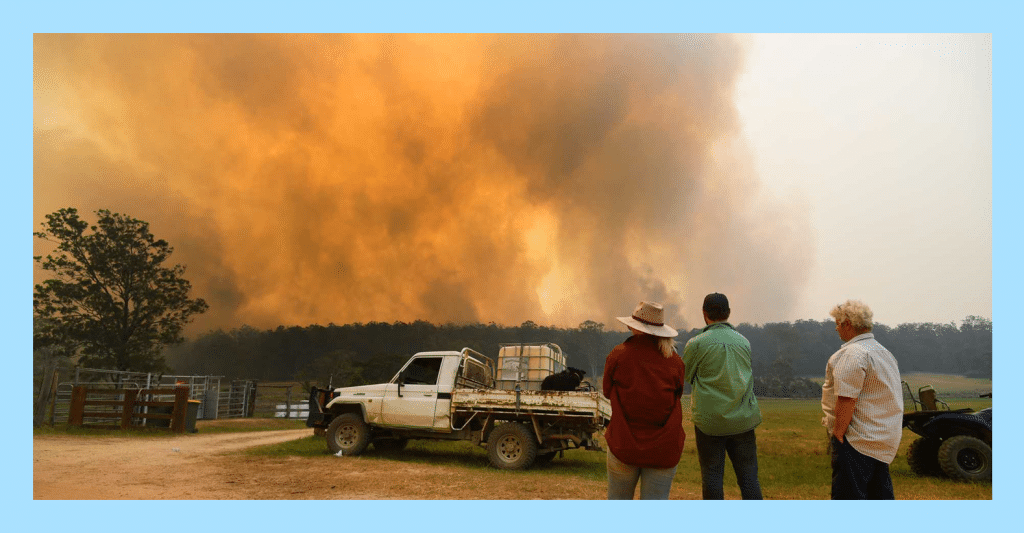 Family looks on to raging bushfires near their property