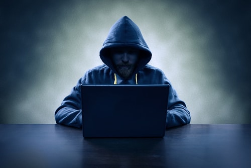 Hooded Computer Hacker Stealing Information With Laptop